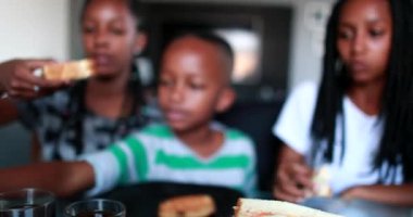 Children eating afternoon snack at home. Black African ethnicity kids snacking sandwiches