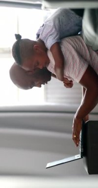 Father using laptop at home with child son hugging