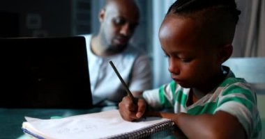 Evde bilgisayar kullanarak birden fazla iş yapan bir baba. Samimi özgün ve gerçek hayatta baba çalışıyor ve ebeveynlik yapıyor.