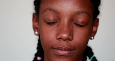 Portrait black teen child girl closing and opening eyes. Adolescent African American girl