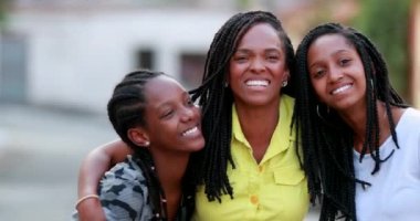 Komik anne dışarıda kızlarına sarılıyor. Afrikalı siyah etnik köken aile sevgisi ve sevgisi