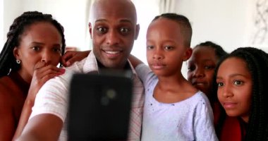 Afrikalı aile cep telefonu cihazını tutarak başarıyı kutluyor