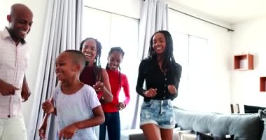 Happy African descent family dancing in celebration feeling joy