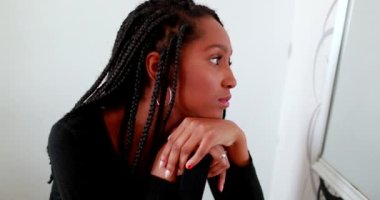 Teen girl looking at herself in front of mirror