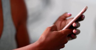 Yakın plan siyah eller akıllı telefon aygıtı tutuyor.