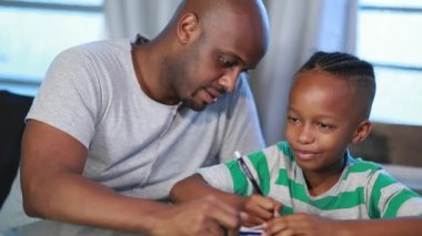 African black father helping son with homework