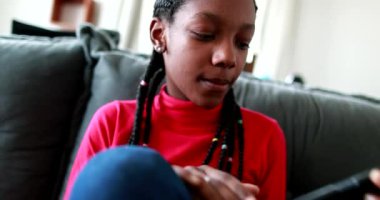 Adolescent teen black girl picking up cellphone device