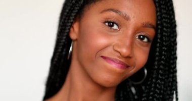 Pretty black teen girl posing smiling at camera. Portrait young African descent woman in 20s