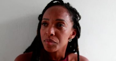 Pensive black African woman leaning on wall