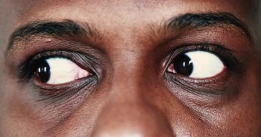 Extreme face close-up, macro eyes of black African man looking sideways