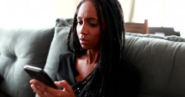 Sinirli siyah kız cep telefonu mesajından rahatsız oluyor.