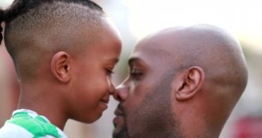 Beautiful father and child bonding together. African black parent and son bonding, doing eskimo kiss