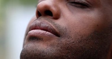 Mutlu Afrikalı adam dalgınlıkla gözlerini kapatıyor ve açıyor