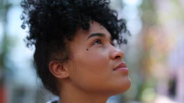 Young black woman looking up to sky with hope and faith