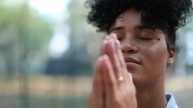 Evangelical mixed race young woman praying to God outside