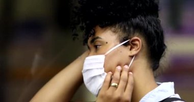 Metroya binen maskeli kız.