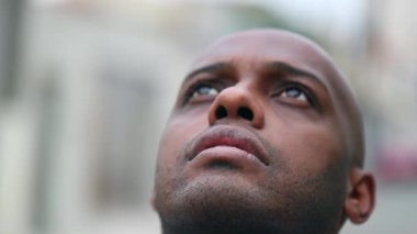 African man opening eyes looking at sky worshiping GOD