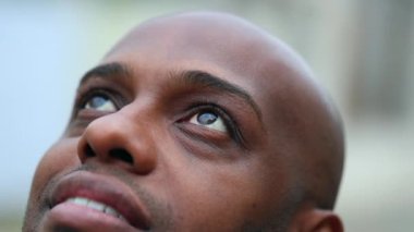 African mixed race man looking up to sky. Close-up Black person in contemplation