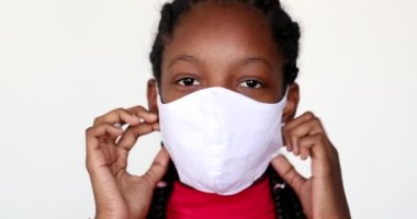 African teen girl removing covid-19 face mask feeling relief