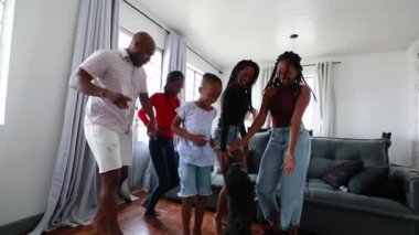 Happy black African family dancing at home living-room