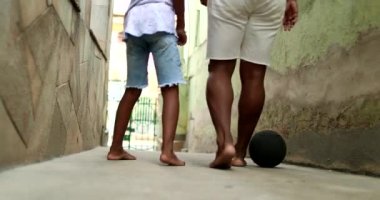 Baba ve oğul birlikte futbol oynuyorlar. Afrikalı ebeveynler çocukla bağ kuruyor. Spor yapmak