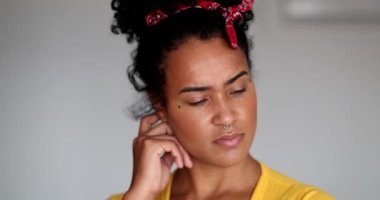 Bir soruna çözüm arayan genç siyahi kadın kameraya bakar.