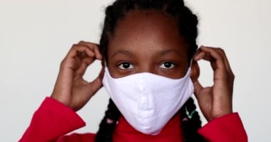 Black girl putting covid-19 face mask