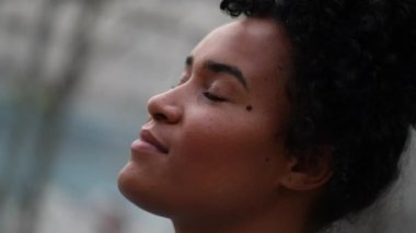Black woman looking up to sky smiling. Hopeful happy African person