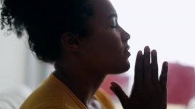 African Brazilian evangelical woman praying at home