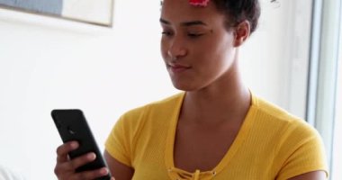 Genç mutlu melez kadın telefonda yumruk okuyarak kutlama yapıyor.