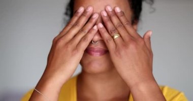 Düşünceli siyah kadın elleriyle yüzünü ovuşturuyor.