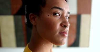 Melez ırk genç siyahi kadın, kameraya bakıyor.