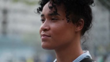 Young black woman taking a deep breath outside