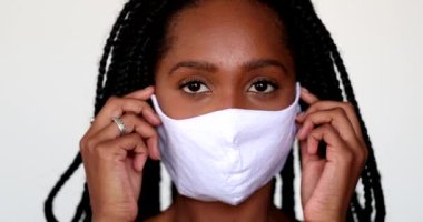 Black girl adjusting covid-19 face mask. African teen wearing mask