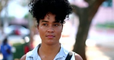 Contemplative hispanic black woman standing outside thinking