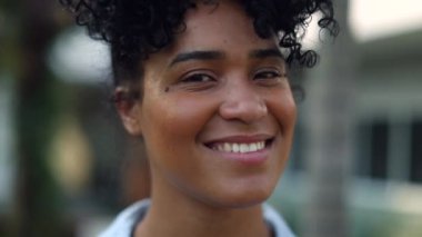 Happy young black woman smiling outside, portrait African American person
