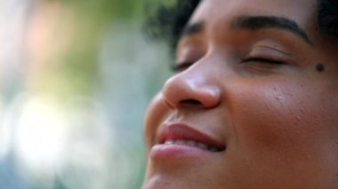 Mixed race woman closing eyes in meditation outside