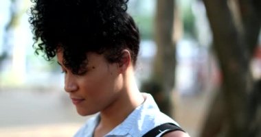 Young black African woman standing outdoors thinking