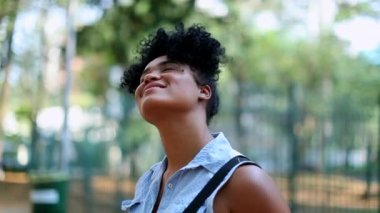 Mixed race young black African woman looking up to the sky smiling