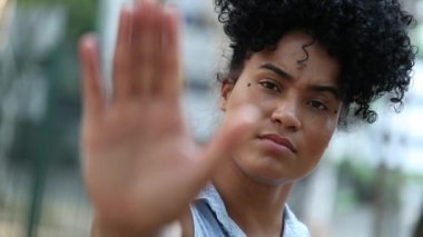 Mixed race woman saying STOP with hand, showing restriction