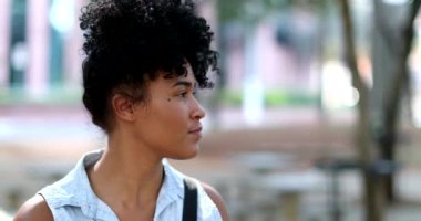 Black woman standing outside observing environment