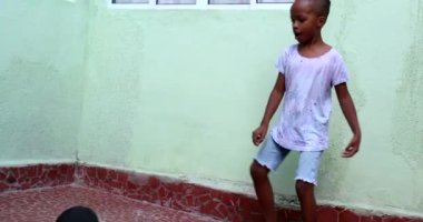 Çocuk, ebeveyn ve çocuk futbol oynarken yetişkinlerin topa vurması