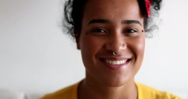 Genç siyah kadın kameraya gülümsüyor.