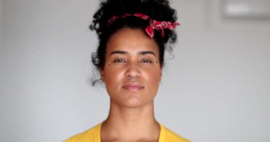 Yüzünde ciddi bir ifade olan genç zenci kadın.