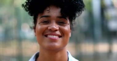 Açık havada gülümseyen mutlu ve çeşitli bir kadın.