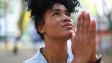 Evangelical mixed race young woman praying to God outside
