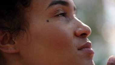 Young woman face opening eyes in meditation and contemplation loooking up at the sky with hope and faith