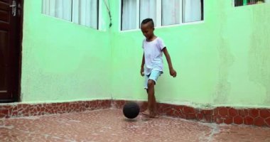 Little boy playing with ball. African ethnicity child plays soccer
