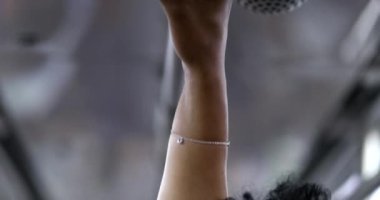 Commuter holding subway handrail wearing covid-19 face mask. Black girl close-up face in public transportation