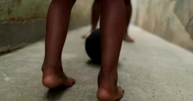 Father and son playing football together. African parent bonding with child. Playing sport